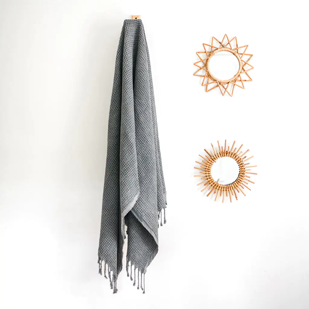 Waffle Weave Turkish Towel hanging with decorative mirrors on white wall.