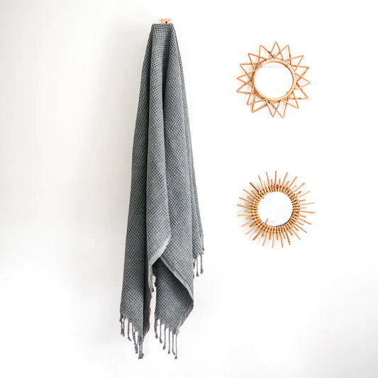 Waffle Weave Turkish Towel hanging with decorative mirrors on white wall.